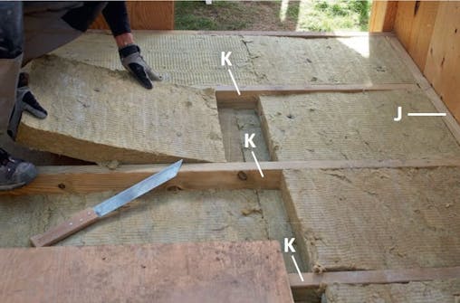 Isolering af gulv i skur med to lag isolering Der lægges to lag isolering til gulv i skur